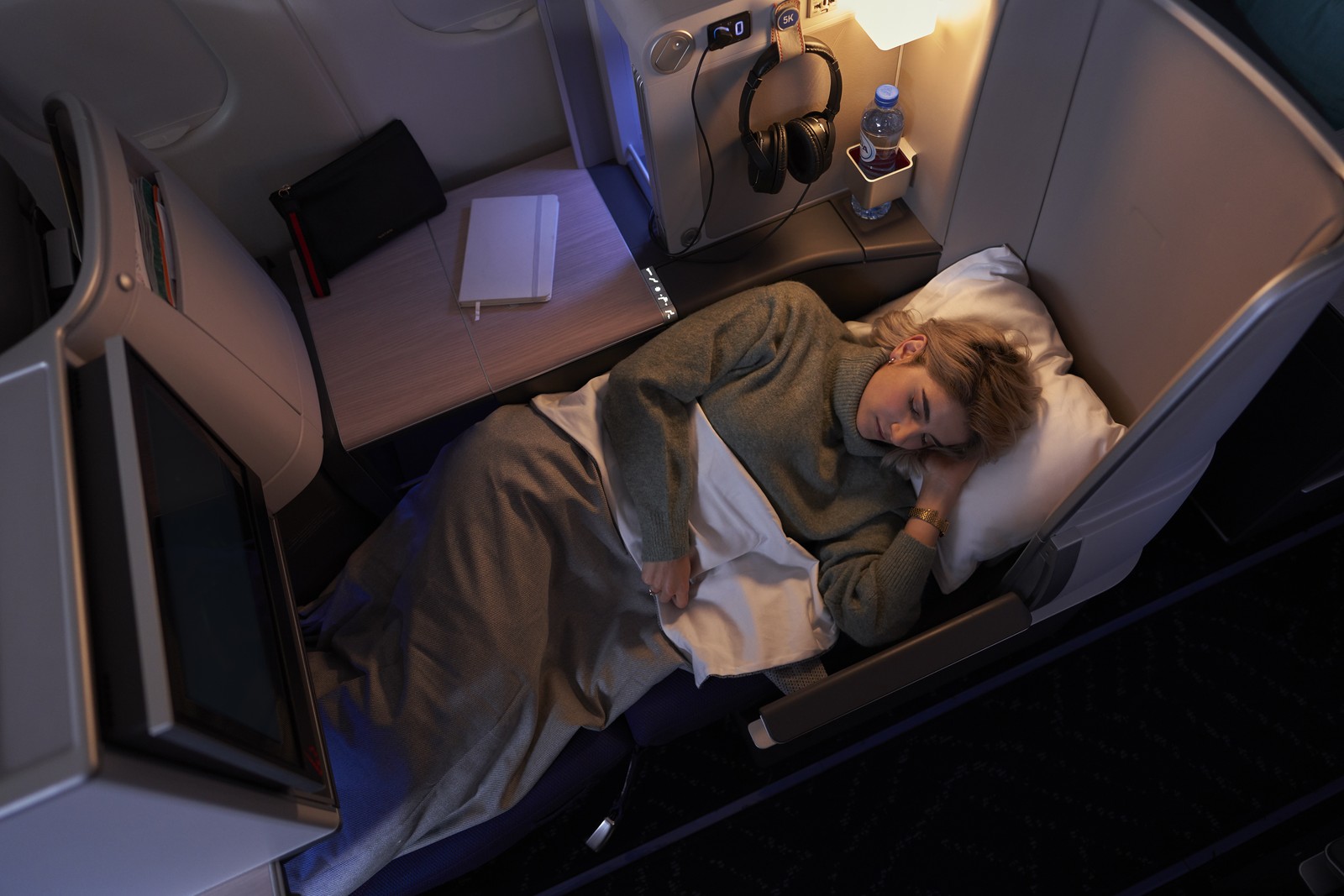 Brussels Airlines Business Class seat in full lie-flat mode with bedding, offering a restful long-haul sleep experience. Photo by Brussels Airlines.