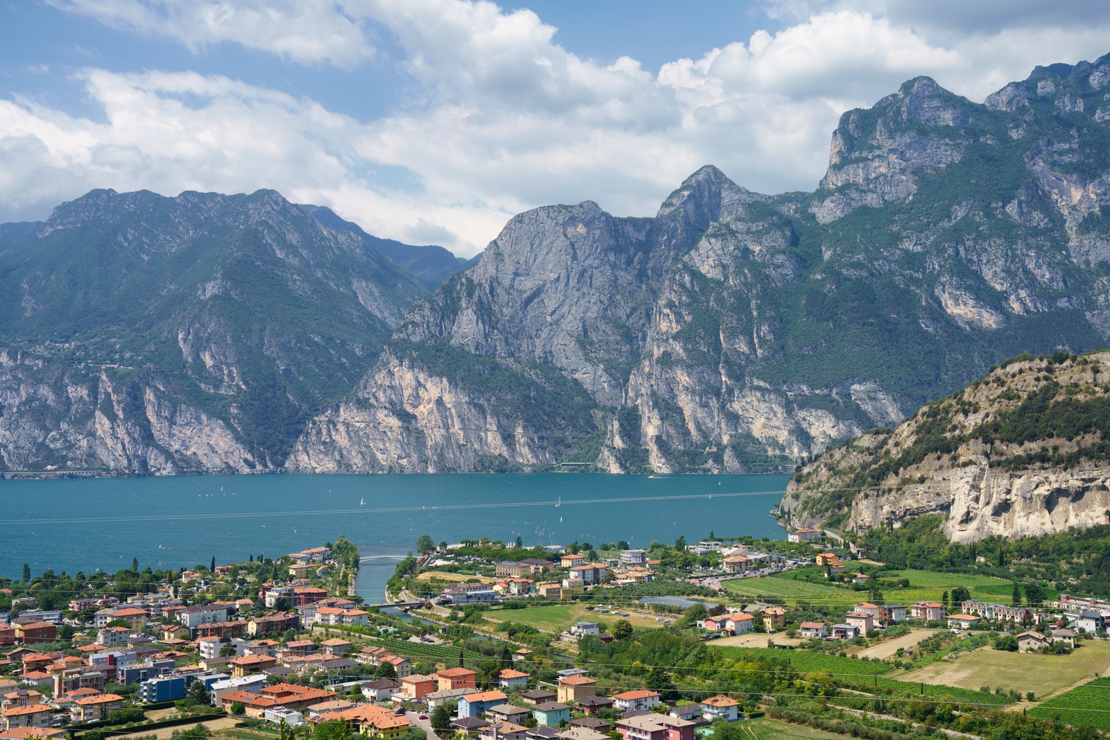 The charming town of Torbole sits at the northern shore of Lake Garda, surrounded by dramatic cliffs and lush mountains, offering a breathtaking view of Italy’s largest lake.