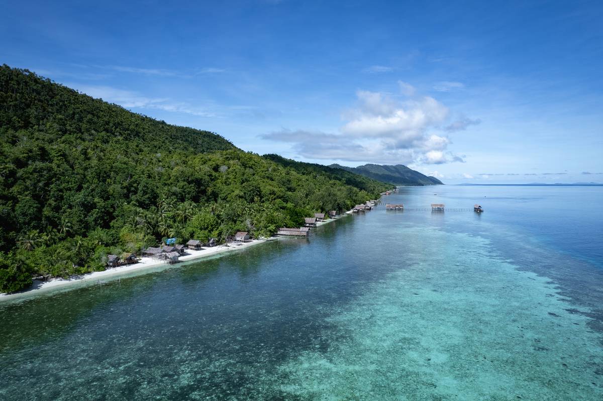 Beach on Kri Island featuring homestay bungalows nestled in the jungle.