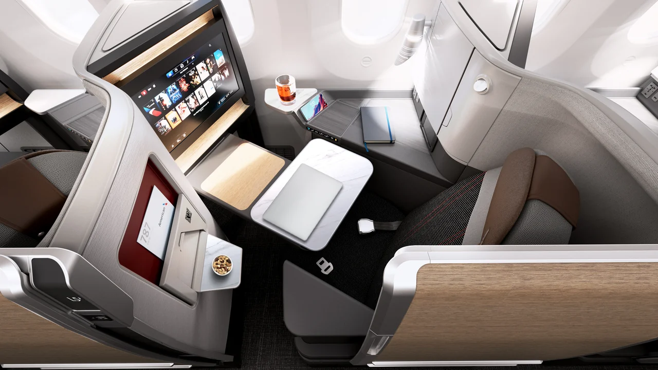Overhead view of American Airlines Flagship Suite dual-level tray table with laptop and cocktail