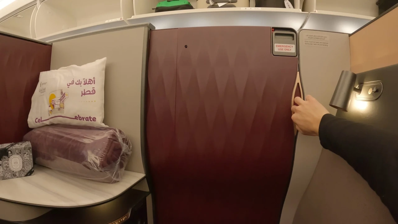 Qatar Airways QSuite business class with closing privacy door. Photo by Qatar Airways.